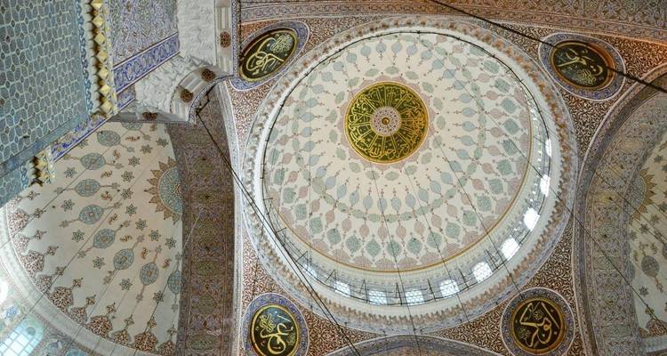 A beautifully ornate interior ceiling of a mosque, likely in Istanbul.