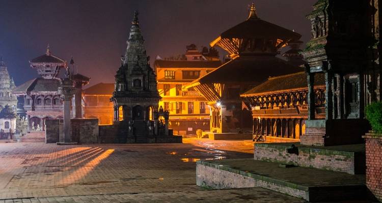 Historischer Platz mit antiker Architektur, nachts beleuchtet.