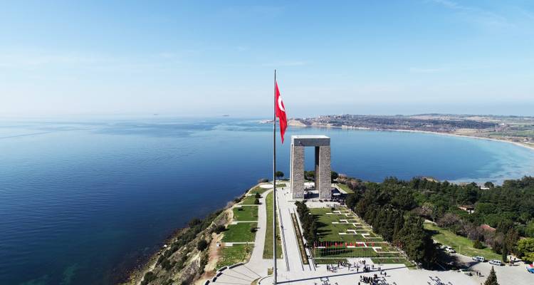 Monumento con una bandera con vista al mar.