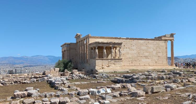 Erecteión con su famoso pórtico de Cariátides con vistas a Atenas, visitantes dispersos alrededor de las ruinas