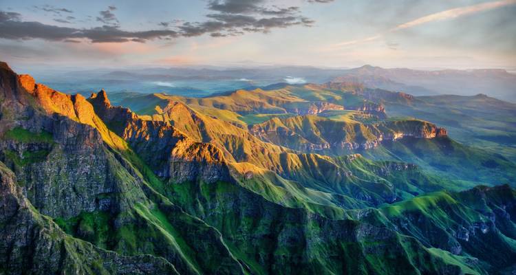 Stunning sunrise view over rolling landscapes and peaks.