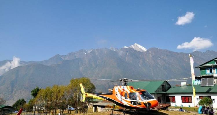 Helikopter geparkeerd in bergachtig gebied met gebouwen