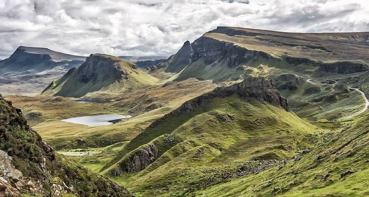 Malerische Aussicht auf die Quiraing-Landschaft mit schroffen Hügeln und einem ruhigen Loch.