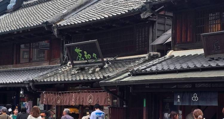 Narrow street lined with traditional wooden merchants’ houses bustling with visitors.