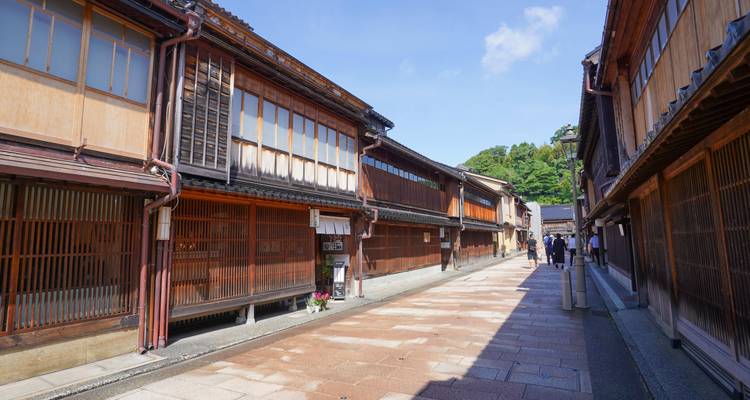 Sunlit wooden teahouses flank a narrow stone lane in Kanazawa’s Higashi Chaya District.