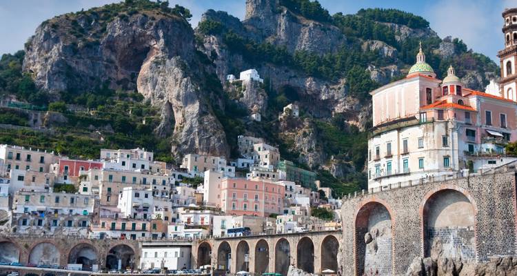 Une ville côtière colorée à flanc de falaise avec une architecture historique.
