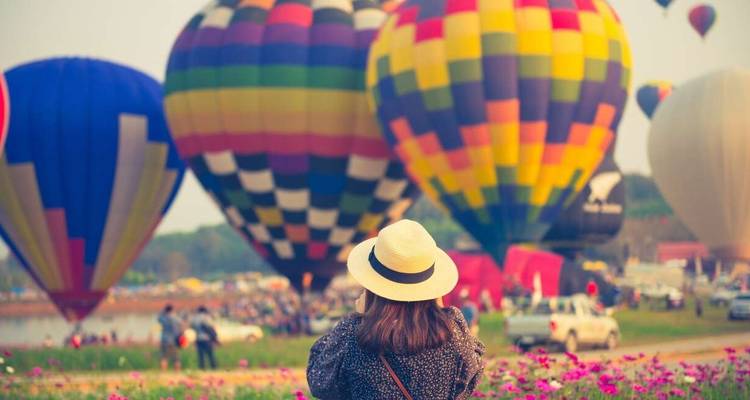Frau fotografiert bunte Heißluftballons