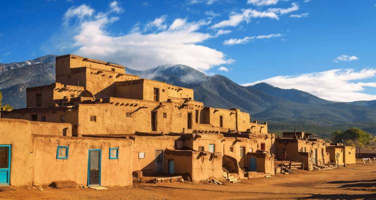 Adobe-Pueblo-Dorf mit Bergen im Hintergrund