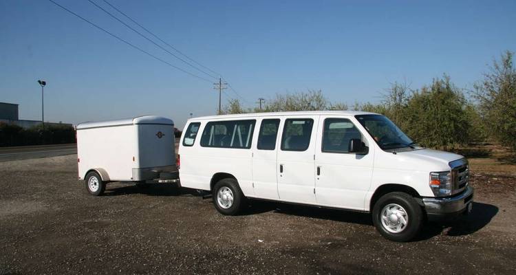 Weißer Lieferwagen mit angehängtem Anhänger