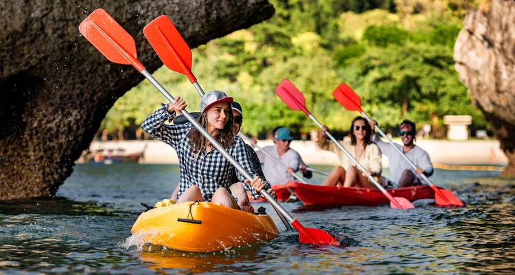 Kayak de groupe à travers des eaux turquoise avec une végétation luxuriante.