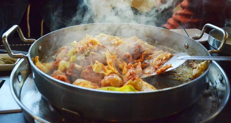 Un plat fumant de cuisine coréenne en cours de préparation.