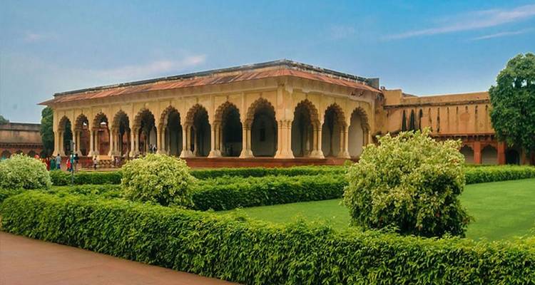 Tuinzicht met historisch gebouw op de achtergrond.