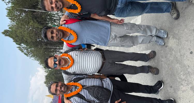 Vier Männer posieren zusammen an einem Ort im Freien.