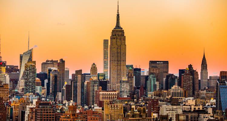 Colorido horizonte de la ciudad de Nueva York al atardecer con rascacielos prominentes.