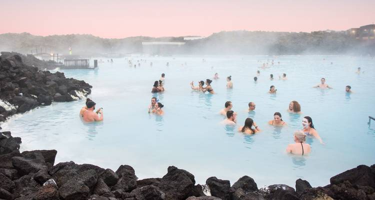 Des gens profitant du Blue Lagoon avec de la vapeur s'élevant de l'eau.