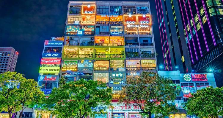 Lebendiges Einkaufs- und Restaurantgebäude bei Nacht.