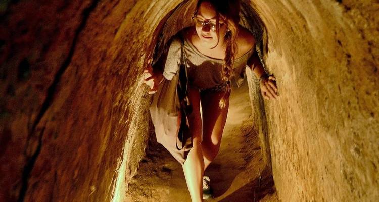 Person, die das Cu-Chi-Tunnelsystem erkundet.