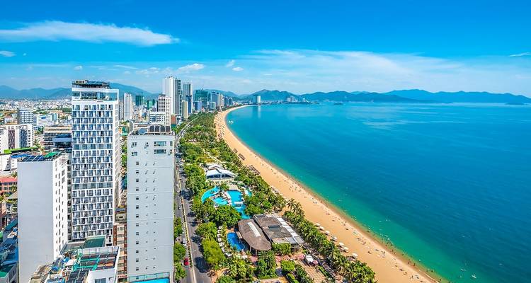 Küstennahe Stadtlandschaft von Nha Trang mit Hochhäusern und Strand.