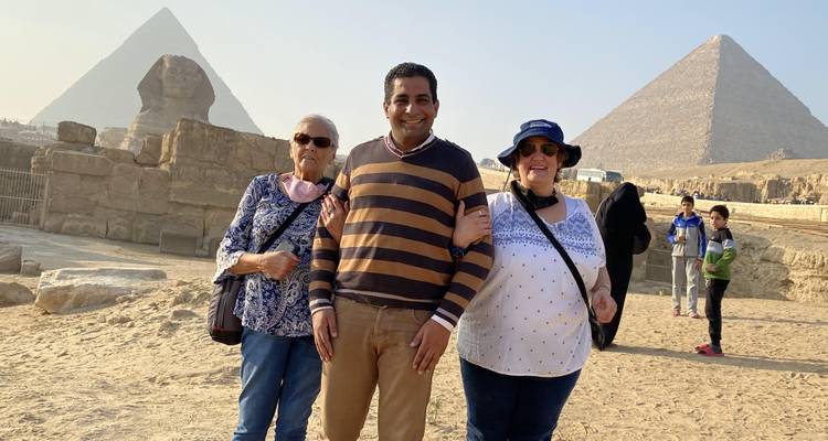 Drei Menschen posieren mit Pyramiden im Hintergrund