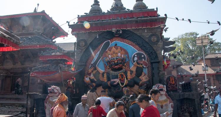 Temple with stone carvings and a crowd of people.