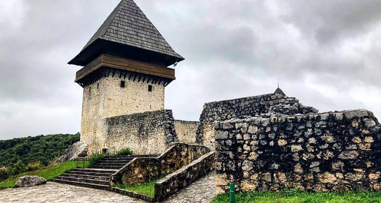 Een stenen toren en vesting op een bewolkte dag.