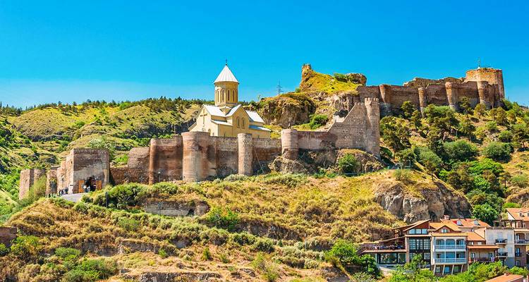 Uitzicht op een historische vesting en kerk op een heuvel.
