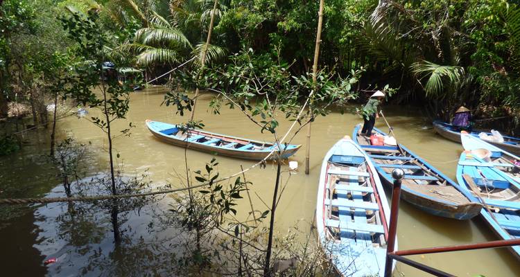 Barcos anclados en un canal rodeado de exuberante vegetación.