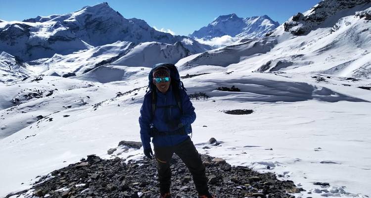 Eine Person auf schneebedecktem Gelände mit atemberaubend hohen Bergen.