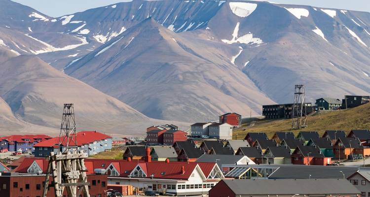 L'établissement arctique coloré de Longyearbyen avec ses maisons aux toits rouges sous des montagnes nues et striées de neige.