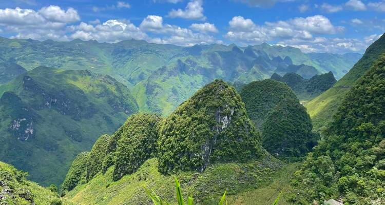 Malerische Aussicht auf üppig grüne Karstberge unter blauem Himmel.