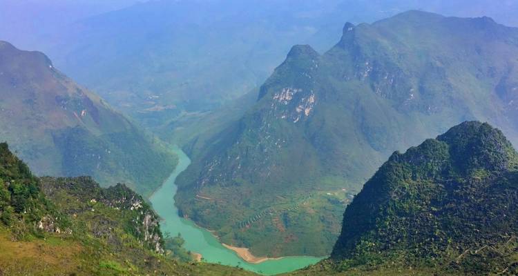 Luftaufnahme eines sich schlängelnden Flusses durch eine Berglandschaft.