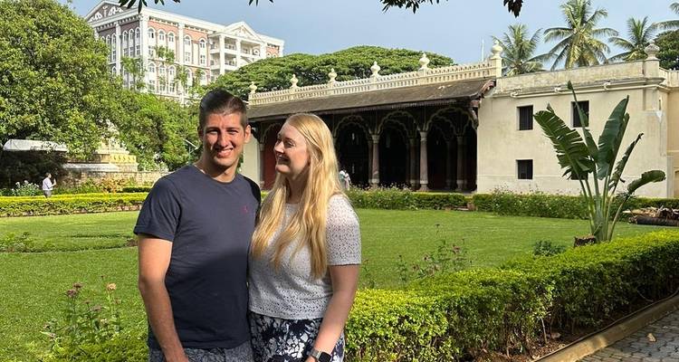 Paar vor einem historischen Gebäude mit Grünpflanzen.