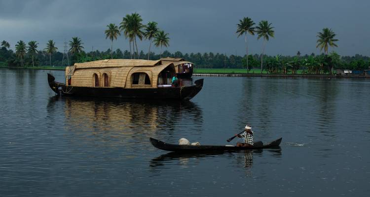 Woonboot op een rivier met weelderig groen.