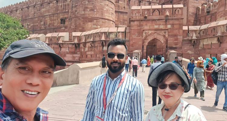 Touristen, die außerhalb der massiven Mauern und des Tors des Agra Fort ein Selfie machen und lächeln