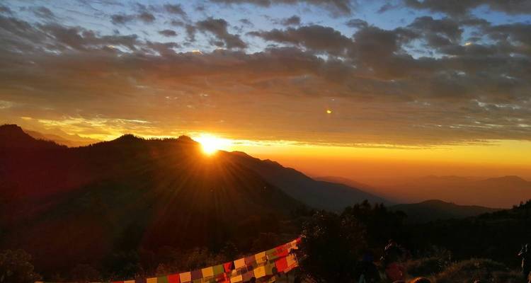 Sunset view with mountains and prayer flags in the foreground.
