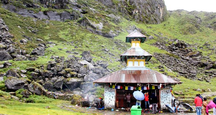 Small temple surrounded by rocks and greenery.