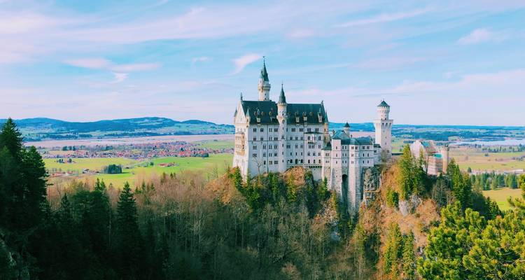 Neuschwanstein Castle on a hill with expansive views of the countryside.