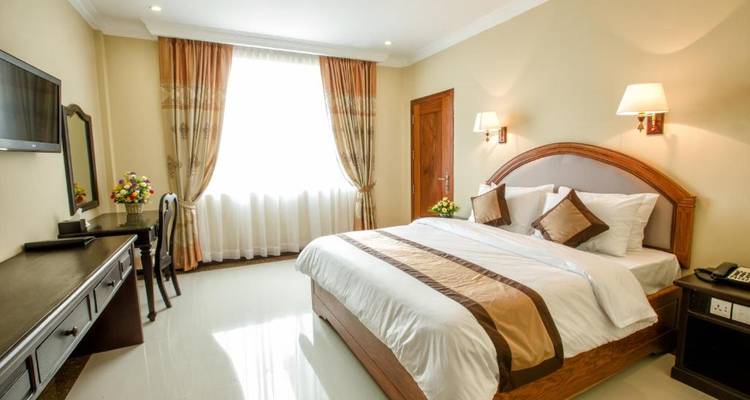 Ein Hotelzimmer mit einem großen Bett, Holzdekor und einem Fenster.