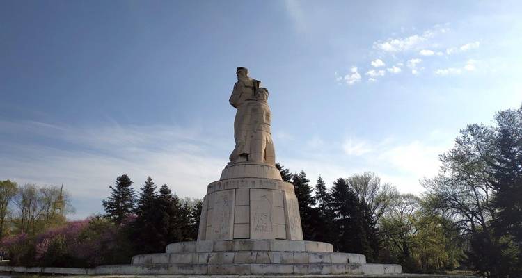 Denkmal mit zwei Figuren in einer Parkanlage.