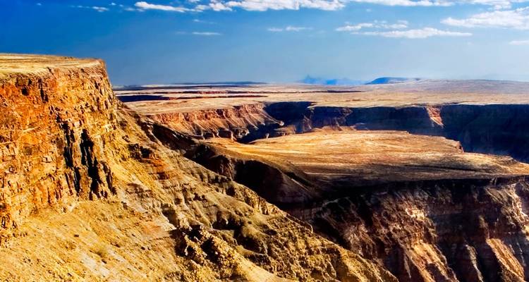 Farbenfrohe, geschichtete Felsklippen eines riesigen Canyons unter einem strahlend blauen Himmel