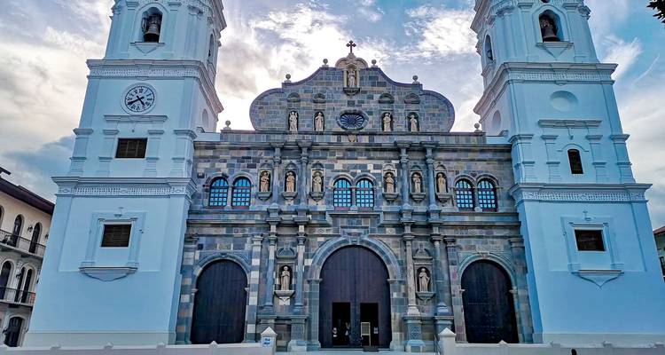 Fachada de una iglesia grande con dos campanarios bajo un cielo nublado.