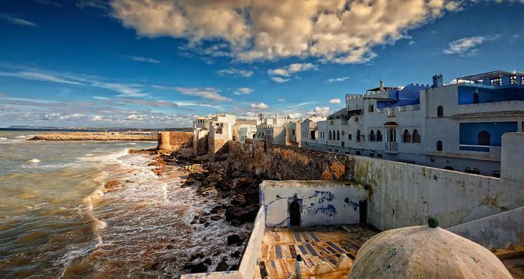 Küstenblick auf Asilah, Marokko mit weißen Gebäuden und dem Ozean.