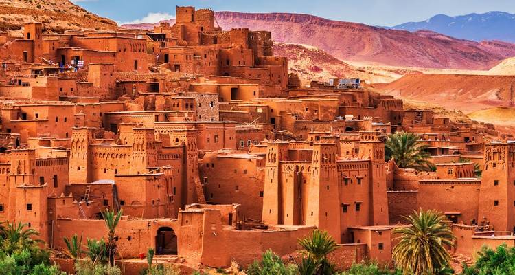 Ait Benhaddou kasbah met groene palmbomen.