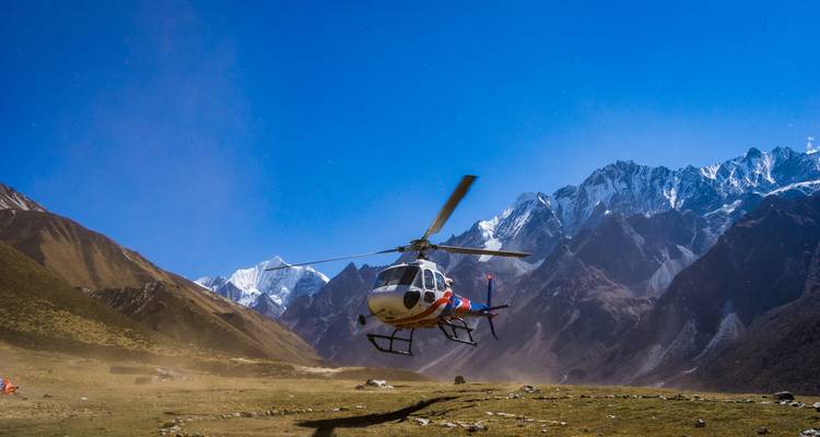 Helicopter flying over a mountainous area.