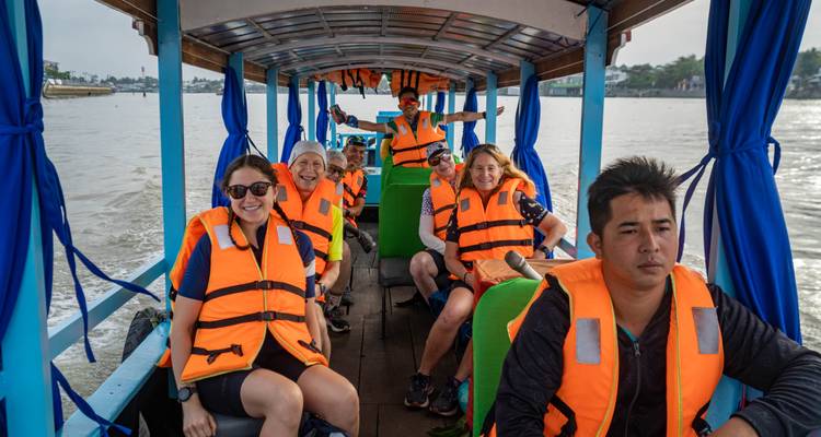 Gruppe von Menschen mit Schwimmwesten auf einem Boot.
