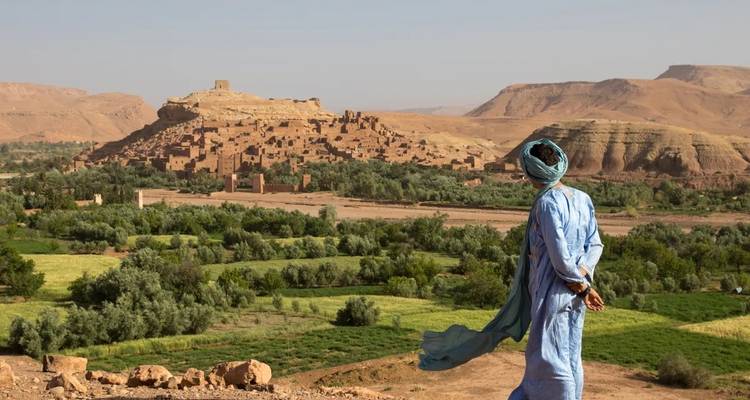 Man die Ait Benhaddou overziet vanaf een heuveltop.
