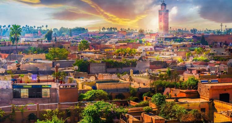 Eine Skyline einer Stadt mit einer markanten Moschee bei Sonnenuntergang.