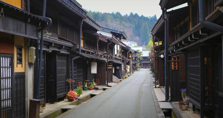 Traditionelle japanische Holzgebäude, die eine schmale Straße säumen.