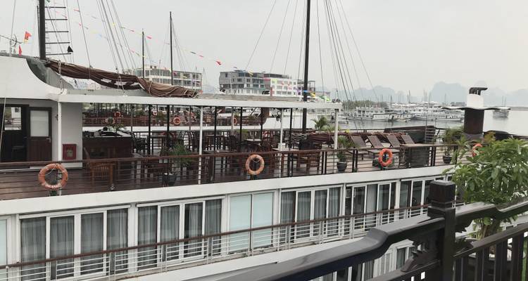 Ein großes Kreuzfahrtschiff an einem Dock unter einem bewölkten Himmel.