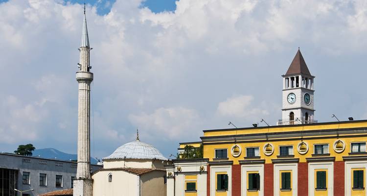 La Tour de l'Horloge et la Mosquée d'Et'hem Bey dominent la ligne d'horizon du centre de Tirana contre un ciel partiellement nuageux